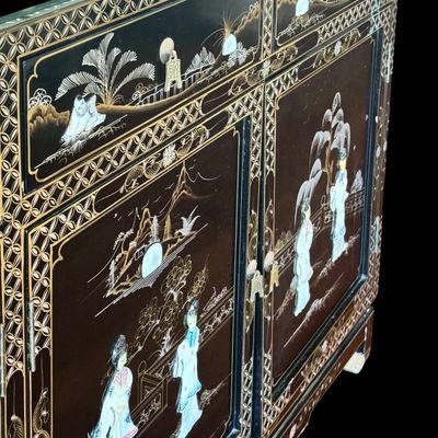 Sale Photo Thumbnail #179: A large black lacquer and mother-of-pearl inlaid figural sideboard depicting the popular “Royal Ladies” narrative scene. Constructed with four central cabinet doors and four upper drawers. The craftsmanship reflects the traditional East Asian furnitur