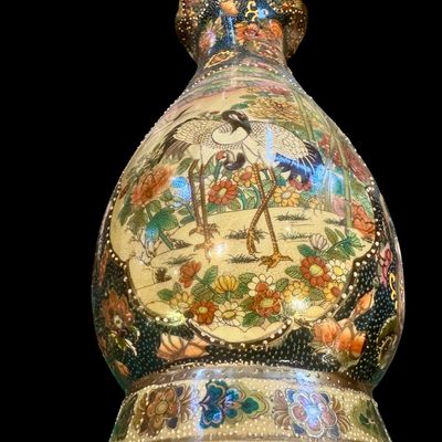 Sale Photo Thumbnail #265: Chinese Satsuma earthenware characterized by its crackle glaze and dense, polychrome enamel decoration. The vase features a lobed rim and a classic baluster form. The body is adorned with intricate scenes including cranes~ a symbol of longevity, flower mo