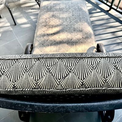Sale Photo Thumbnail #281: This  pair of vintage chaise lounges features a durable cast aluminum frame finished in a matte black powder coat, characterized by intricate, lattice-style openwork on the frame and legs. This piece is mounted on two functional wheels, facilitating easy 