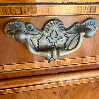 Sale Photo Thumbnail #105: This exquisite Queen Anne style highboy features a classic bonnet-top (or swan's neck) pediment adorned with a central carved shell motif and finials. The piece is constructed with rich, figured walnut veneers, showcasing intricate grain patterns across t