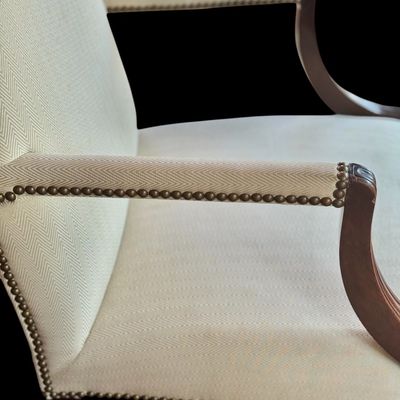 Sale Photo Thumbnail #151: Handsome pair of Chippendale style arm chairs featuring a high, slightly arched back and fluted, dark stained wooden arms and legs. The chairs are upholstered in a neutral chevron pattern fabric, accented with decorative brass tone nailhead trim along the