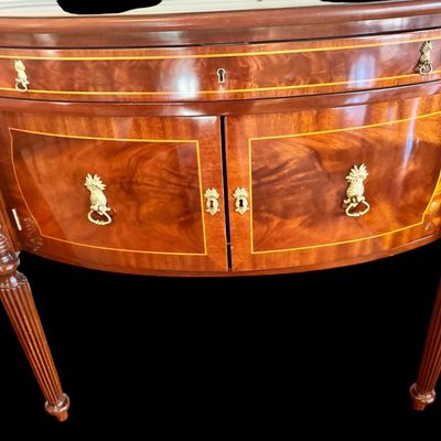 Sale Photo Thumbnail #84: Elegant and high quality Kindel Furniture sideboard executed in the Federal Style with refined neoclassical elements. It features a bow front design, characteristic of the period with flame mahogany veneers, and contrasting stringing inlay. The piece is s