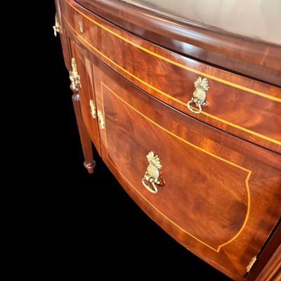 Sale Photo Thumbnail #82: Elegant and high quality Kindel Furniture sideboard executed in the Federal Style with refined neoclassical elements. It features a bow front design, characteristic of the period with flame mahogany veneers, and contrasting stringing inlay. The piece is s