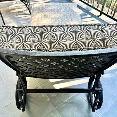 Sale Photo Thumbnail #282: This  pair of vintage chaise lounges features a durable cast aluminum frame finished in a matte black powder coat, characterized by intricate, lattice-style openwork on the frame and legs. This piece is mounted on two functional wheels, facilitating easy 