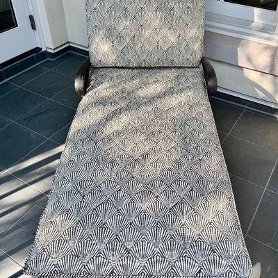 Sale Photo Thumbnail #274: This  pair of vintage chaise lounges features a durable cast aluminum frame finished in a matte black powder coat, characterized by intricate, lattice-style openwork on the frame and legs. This piece is mounted on two functional wheels, facilitating easy 