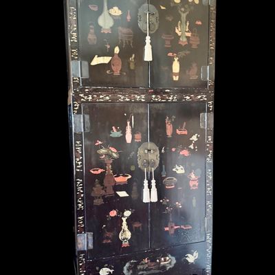 Sale Photo Thumbnail #184: A 19th-century Chinese Shanxi lacquered wood two-part compound wardrobe cabinet. The piece is decorated with traditional motifs including floral arrangements, landscape scenes and figures. It is equipped with ornate brass hardware. The interior features a