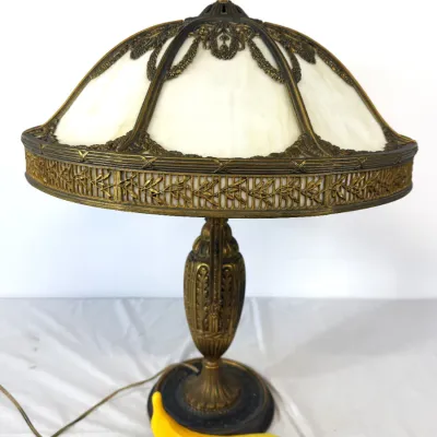 Sale Photo Thumbnail #20: Antique slant-six panel slag glass table lamp with an ornate bronzed metal frame and base.
