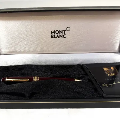 Sale Photo Thumbnail #6: Montblanc Meisterstück Hommage à Wolfgang Amadeus Mozart burgundy ballpoint pen, displayed in its original branded presentation box with accompanying booklet.