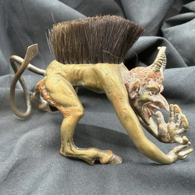 Sale Photo Thumbnail #11: Antique bronze Mephistopheles devil figure clothes brush featuring detailed horned devil features and stiff bristle back, early 20th century.