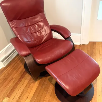 Sale Photo Thumbnail #27: Scandinavian-style burgundy leather recliner and matching ottoman set featuring a dark wood bentwood frame on swivel circular bases.