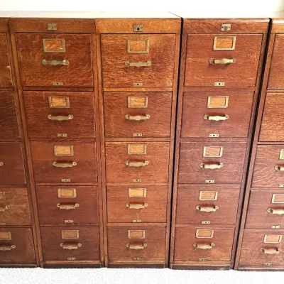 Sale Photo Thumbnail #17: Set of five vintage oak five-drawer filing cabinets featuring brass hardware, label holders, and top keylocks.