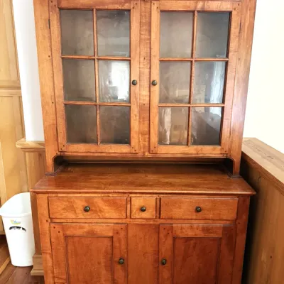 Sale Photo Thumbnail #22: Traditional wooden step-back hutch with glass paned cabinet doors above three drawers and a two-door lower storage cabinet.