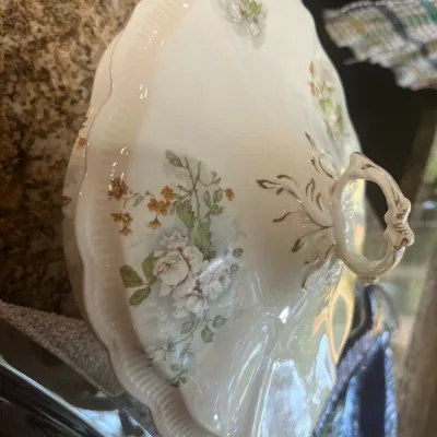 Vintage covered porcelain tureen or serving dish featuring a delicate floral pattern with gold accents and scalloped edges.