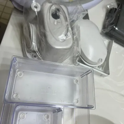 Assorted clear plastic storage organizers shown alongside white and gray plastic home items.