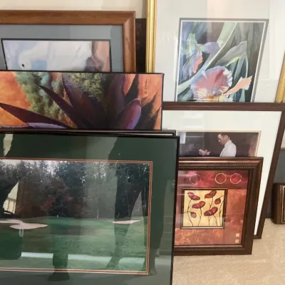 Collection of framed art prints and photographs, featuring floral art, landscapes, and portraits in various wood and metal frames.