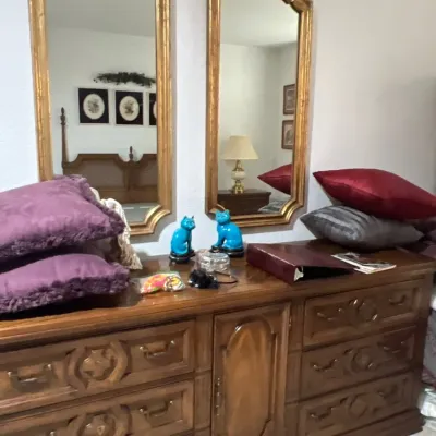 Vintage Spanish revival style wooden dresser with matching tall gilt-framed wall mirrors, paired with turquoise cat figurines and...