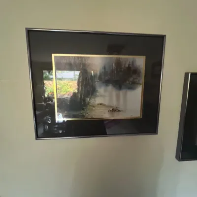 Framed watercolor landscape print featuring a misty forest scene, presented in a dark mat with gold accent inner trim and a metallic frame.