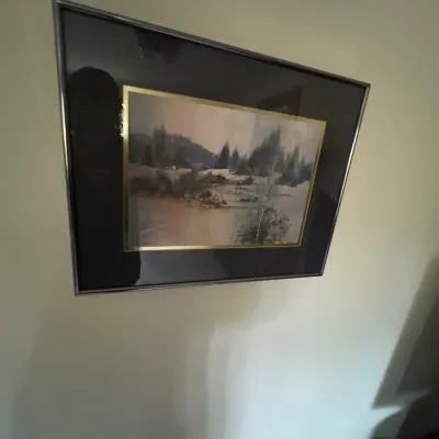 Framed watercolor landscape painting featuring a foggy forest scene, mounted with a dark mat and thin metallic frame.