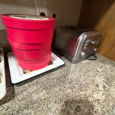 Cuisinart stainless steel four-slice toaster alongside a set of bright pink stackable storage boxes sitting on a white tray.