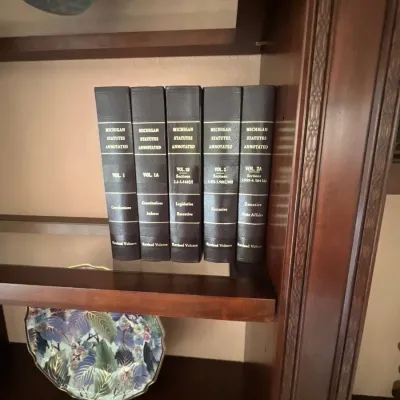 Five-volume set of hardbound "Michigan Statutes Annotated" legal reference books, displayed on a wooden shelf.