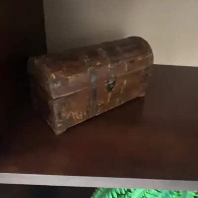Small rustic wooden dome-top treasure chest with metal straps and a distressed finish.