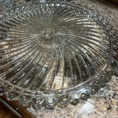 Vintage clear pressed glass serving platter featuring a swirl optic design. and a beaded rim