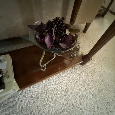 Glass potpourri bowl resting on a wrought-metal pedestal stand, filled with dried purple botanicals and pinecones.
