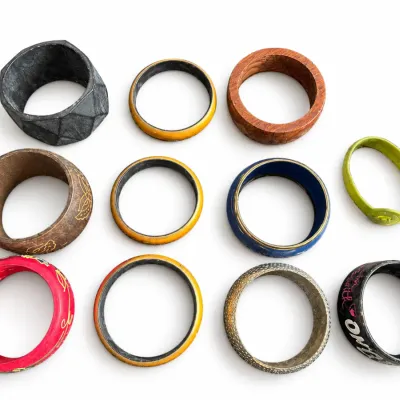 Collection of eleven eclectic vintage bangles and bracelets, including carved wood, painted enamel, metal, and plastic pieces.