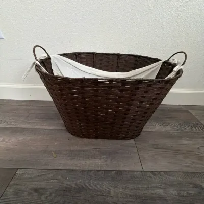 Dark brown woven laundry hamper with a removable white fabric liner and built-in side handles.