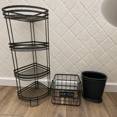 Black metal housewares group including a four-tiered corner mesh shelf, a wire basket labeled 'FARM FRESH', and a small plastic...