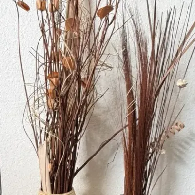 Pair of tall decorative floor vases, including a grooved ceramic vase and a metallic snakeskin-pattern vase filled with dried botanicals.
