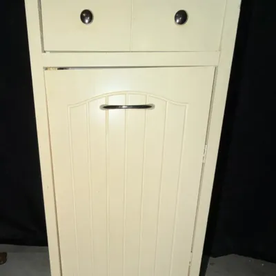 Off-white wooden kitchen utility cabinet featuring a natural wood top, top storage drawer, and beadboard panel cabinet door.