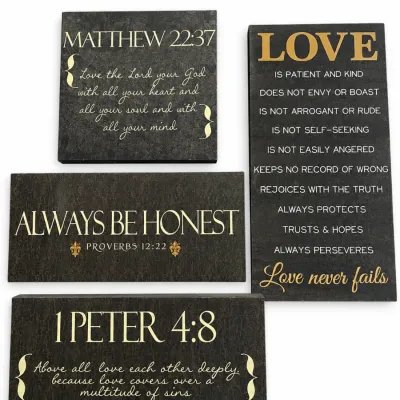 Set of four modern wall art plaques featuring biblical scripture and inspirational text in gold lettering on textured black backgrounds.