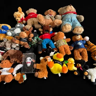 Large collection of assorted plush stuffed animals, featuring various teddy bears, wild animals, and a Ty Beanie Baby panda in a plastic...