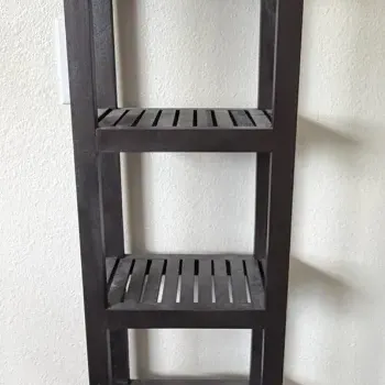 Tall dark brown wooden slatted shelf tower with six tiers, suitable for bathroom or accent storage.