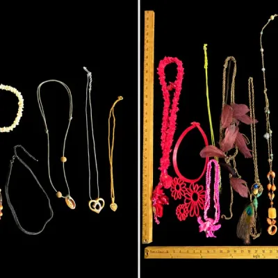 Assortment of vintage and modern fashion necklaces, including beaded strands, pendant chains, and statement pieces displayed next to...