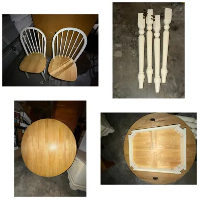 Disassembled wooden dining set featuring a round light-wood tabletop, two white fan-back chairs with natural wood seats, and four painted...