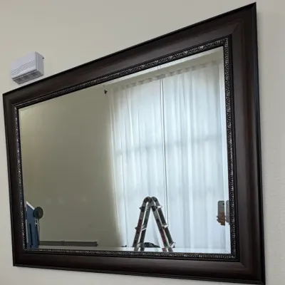 Large wall mirror featuring a dark brown composite frame with a decorative beaded inner border.