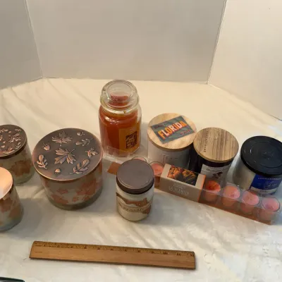 Collection of assorted jar candles, tealights, and autumn-themed candle holders, shown next to a 12-inch wooden ruler for scale.