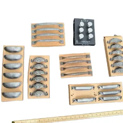 Collection of assorted cabinet hardware including textured metal bin pulls, ornate drawer handles, and a 6-pack of BINO cabinet knobs.