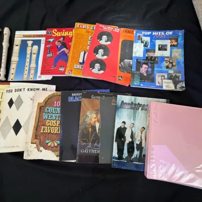 Collection of vintage sheet music, songbooks, instructional music books, and a cream-colored Yamaha recorder with its original carrying...