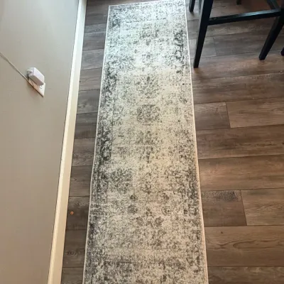 Modern distressed runner rug featuring an ornate traditional pattern in cream and charcoal grey tones.