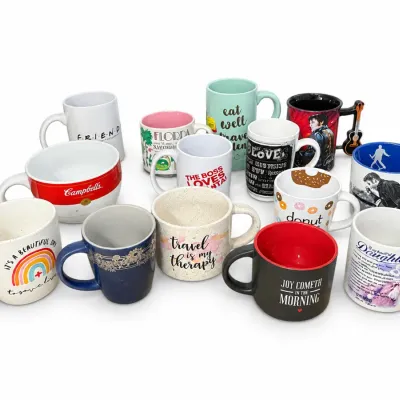Collection of assorted ceramic novelty mugs featuring various themes, pop culture designs, and motivational quotes.
