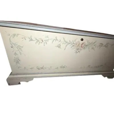 Vintage hand-painted wooden blanket chest featuring delicate floral garlands on an off-white background with blue trim.