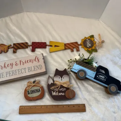 Collection of autumn and Thanksgiving themed home decor, featuring a wooden "FALL" banner, a "Turkey & Friends"...