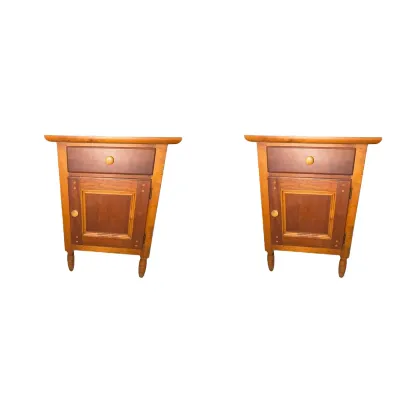 Pair of two-tone wood nightstands featuring a top drawer, lower cabinet door, and wooden knobs.