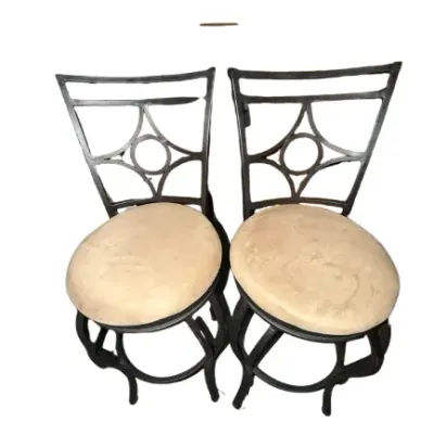 Pair of dark metal swivel counter stools with geometric backs and beige upholstered round cushion seats.