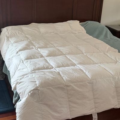 Traditional dark wood king bed frame with panel headboard, featuring a fluffy white quilted comforter.