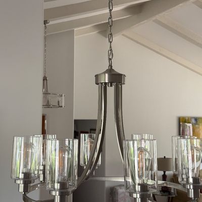 Modern brushed nickel ring chandelier featuring clear glass cylinder shades and Edison-style filament bulbs.