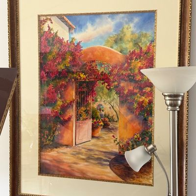Large framed watercolor print by Vikki Reed depicting a Mediterranean archway covered in bougainvillea, housed in a beaded wooden frame.